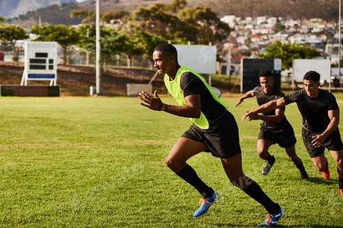 Preview: Full length shot of a diverse group of sportsmen playing a game of rugby during the day