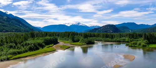Preview: Serene River Flowing Through Forested Valley with Snow-Capped Mountains in BC, Canada