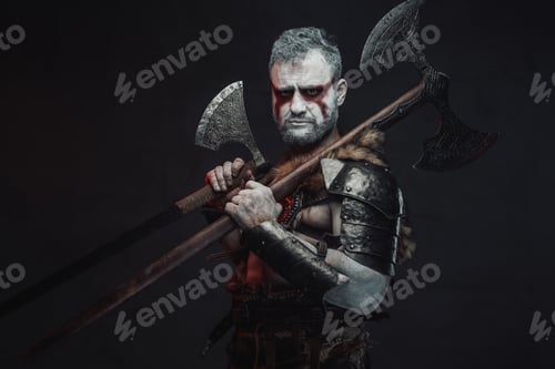 Preview: Serious and violent warrior from fantasy with two axes in studio