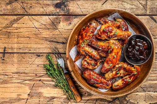 Preview: Grilled chicken wings with bbq sauce. wooden background. Top view. Copy space