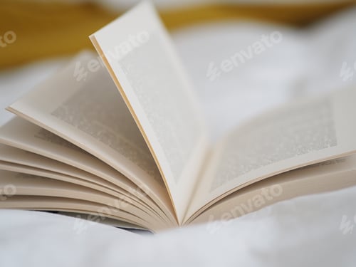 Preview: Selective focus shot of an open book on a white cloth