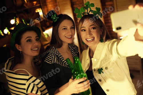 Preview: Women with beer taking selfie in pub. St Patrick's day celebration