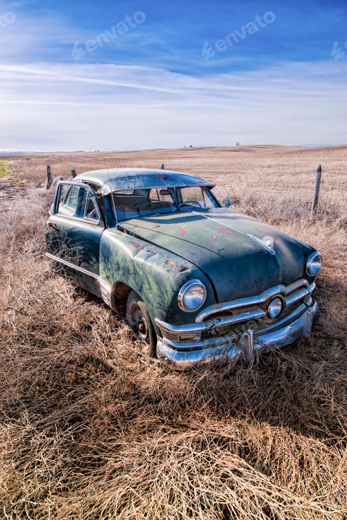 Preview: Old rusted classic car in Washington field.