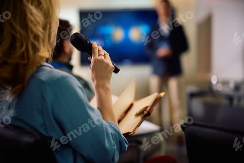 Preview: Close up of businesswoman asking a question during an education event in conference hall.