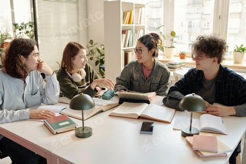 Preview: Four Students Collaborating Working in Study Group at Desk