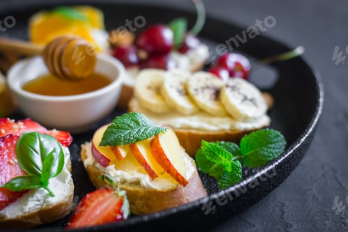 Vista previa: Dish with summer fruit berries nuts honey sandwiches. Selective