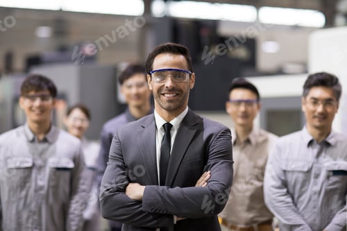Preview: Confident businessman and engineering team in the factory