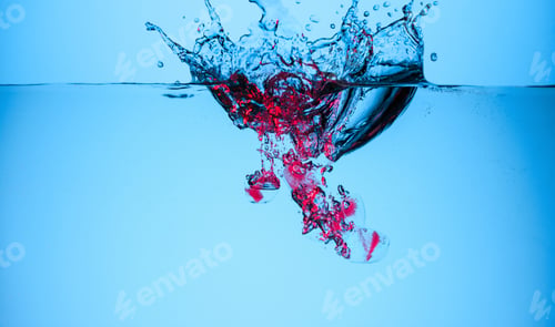 Preview: ice cubes with berries in water with splashes and drops, isolated on blue