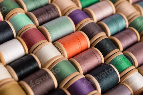 Preview: Sewing background from above. Background from colored cotton threads on spools. Materials for needle