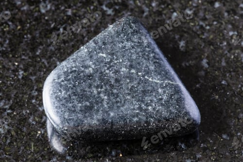 Preview: sample of tumbled dolerite rock on black granite