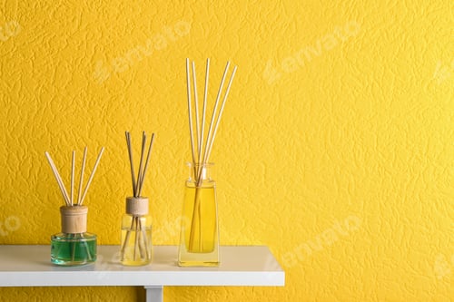 Preview: Reed air fresheners on table against yellow background, space for text