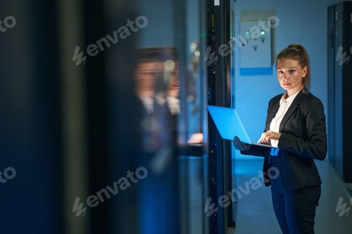 Preview: Female IT professional working in server room with laptop