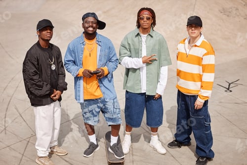 Preview: Group of four young intercultural members of boy band looking at camera