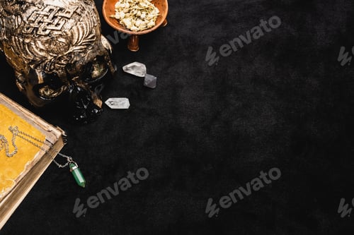 Preview: Top View of Dried Herb in Bowl Near Occult Voodoo Skull And Crystals on Black
