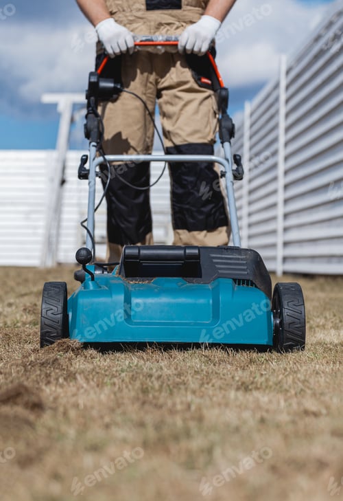 Preview: Scarifying lawn with scarifier, Man gardener scarifies the lawn and removal of old grass