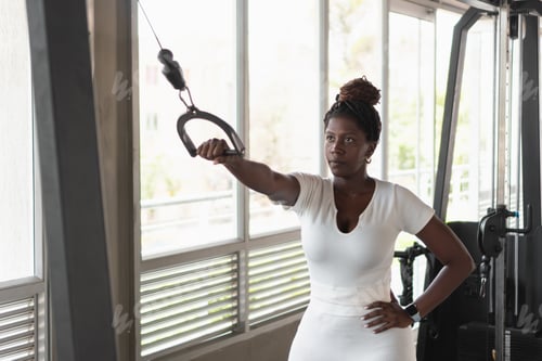 Preview: Focused athlete strengthening triceps with cable machine workout