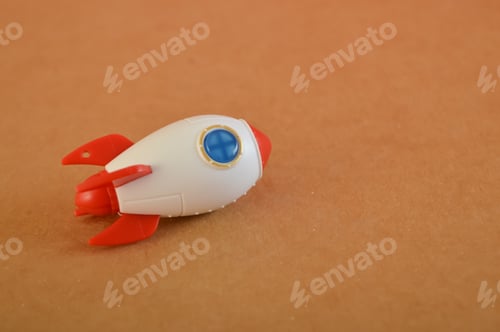 Preview: Toy rocket isolated on a brown background. Start up business concept.