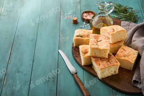 Preview: Focaccia. Italian traditional bread and pastry recipe cut into pieces for serving with olive oil, ar