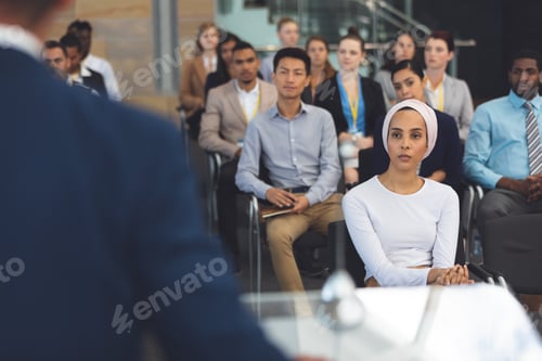 Preview: Group of business professionals listening to speaker at business seminar in modern office building