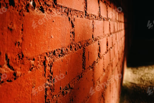 Preview: Old brick wall of red tones illuminated by the afternoon sun.