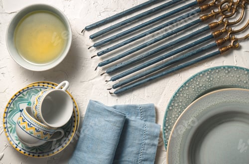 Preview: Hanukkah with candles, plates, butter in a bowl and blue napkin