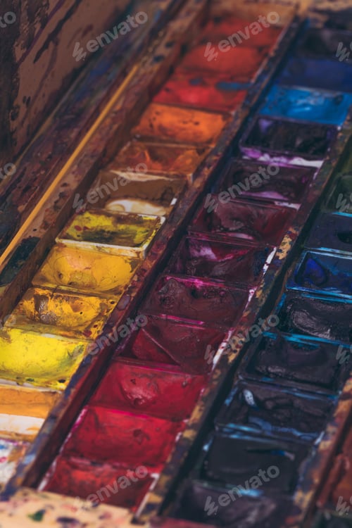 Preview: close-up view of watercolor paints in messy container
