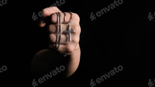 Preview: Close-up images of crucifix pendant necklace in man hand