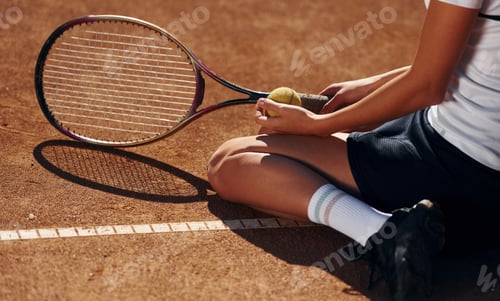 Preview: On the ground. Female tennis player is on the court at daytime