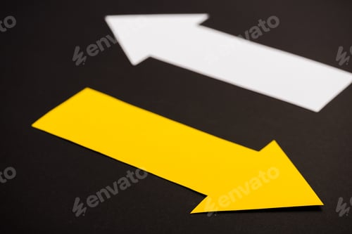 Preview: selective focus of yellow directional arrow isolated on black