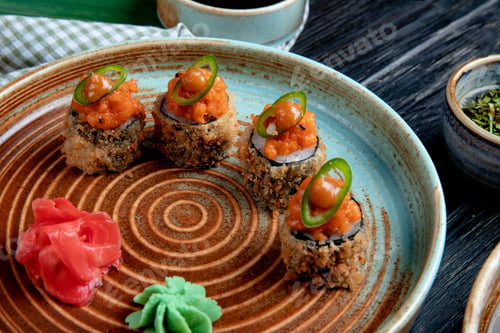 Preview: side view of set of baked sushi rolls with wasabi and ginger on a plate