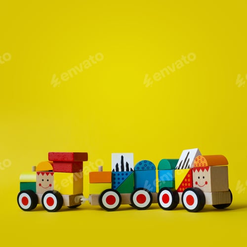Preview: Colorful baby toy on yellow backdrop with copy space.