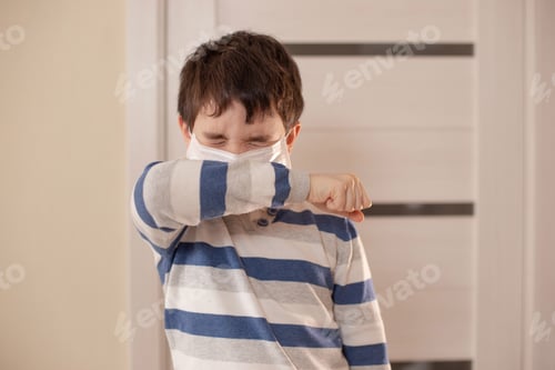 Preview: A boy with closed eyes sneezes or coughs into his elbow.