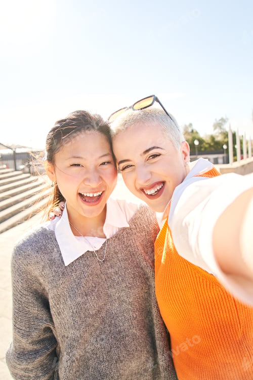 Preview: Selfie of an interracial lesbian happy couple. Smiling Asian woman and a cheerful Caucasian girl