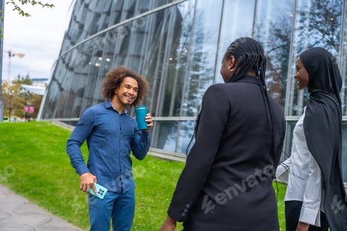 Preview: Diverse colleagues having coffee break outdoors by modern architecture