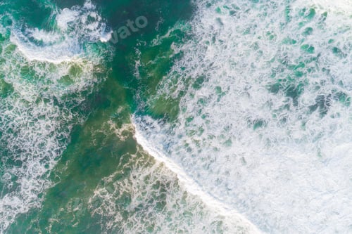Preview: aerial drone view of the foamy waves breaking on the coast, turquoise waters
