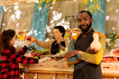 Preview: Male vendor holding squash at food market