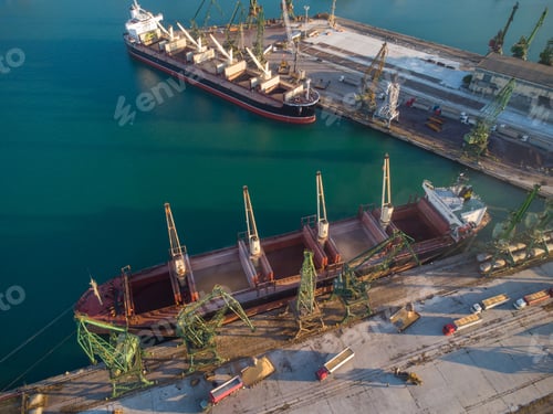Preview: Aerial view of big cargo ship bulk carrier is loaded with grain of wheat in port at sunset