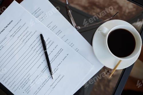 Preview: Top view contracts and coffee cup on glass table in office