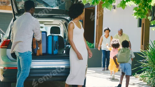 Preview: Grandparents Greeting Grandchildren As Family Unpack Car On Family Holiday