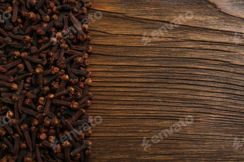 Preview: Aromatic dry cloves on wooden table, flat lay. Space for text