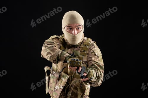 Preview: front view of young soldier in uniform and mask on a black background tank warrior israel
