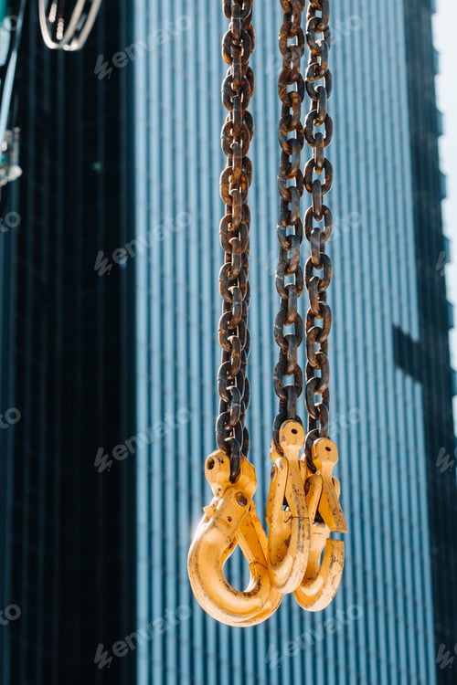 Preview: The hooks of the mobile crane near the glass of high buildings.Lots of hooks hanging from chains