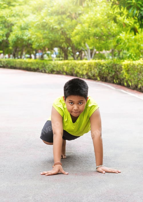 Preview: Young Asian boy prepare to start running on track in the garden during day time to practice himself