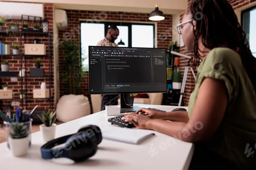 Preview: Woman coder developing software for freelance project working remote from home while boyfriend