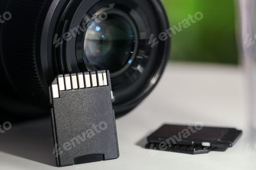Preview: SD memory cards and photo camera on white table, closeup
