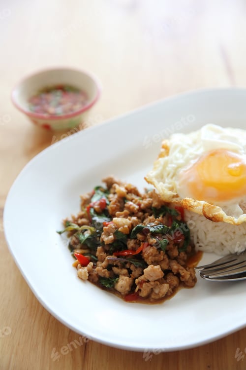 Preview: Stir Fried Pork And Basil With Rice And Egg On Wood Background Thai Food