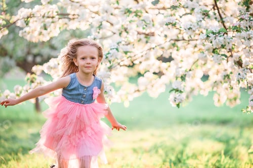 Preview: Adorable little girl enjoying spring day in apple blooming garden