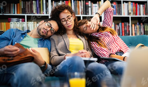 Preview: College, study, university and education concept. Group of tired students learning in library