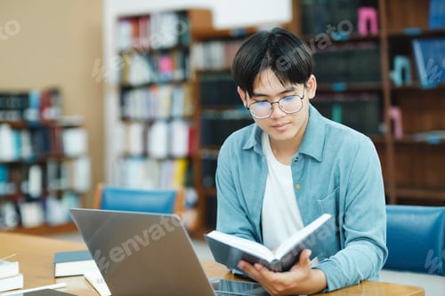 Preview: Young university student using laptop for online learning, searching and learning at library.