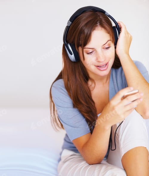 Preview: Cute young woman listening to music on headphones